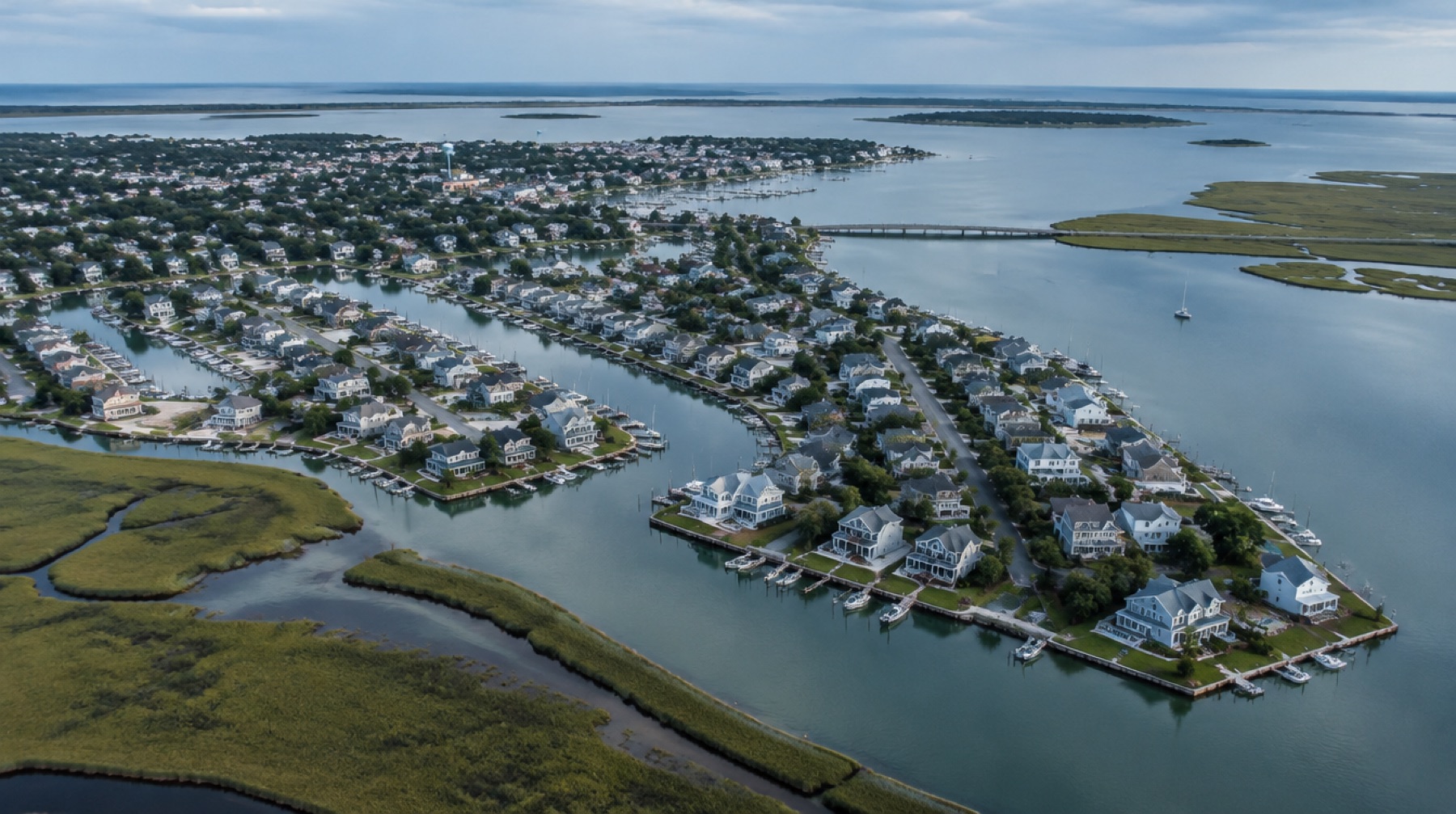 Aerial view of a low-lying coastal town along canals and a bay