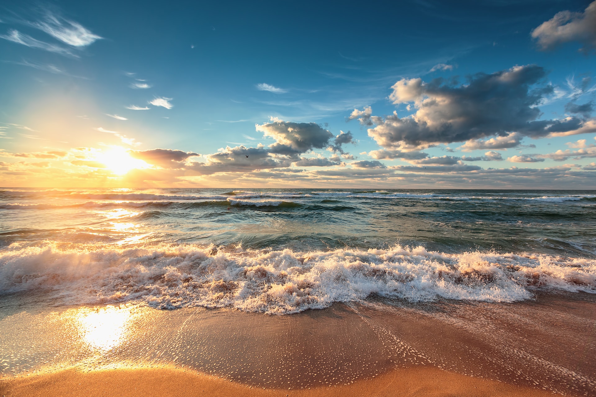 Waves breaking on a sandy beach at sunrise
